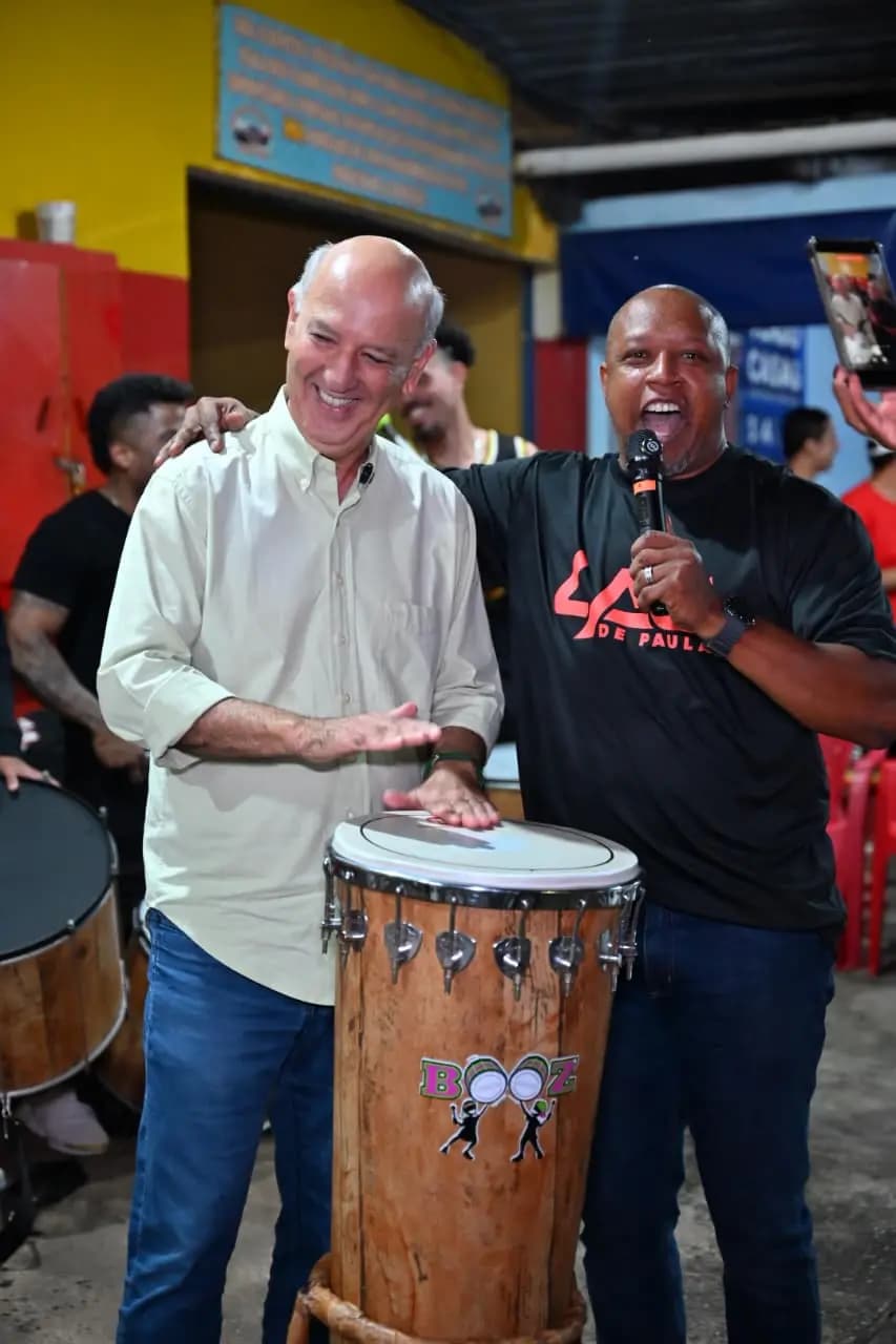 Lau de Paula com um microfone ao lado de um músico